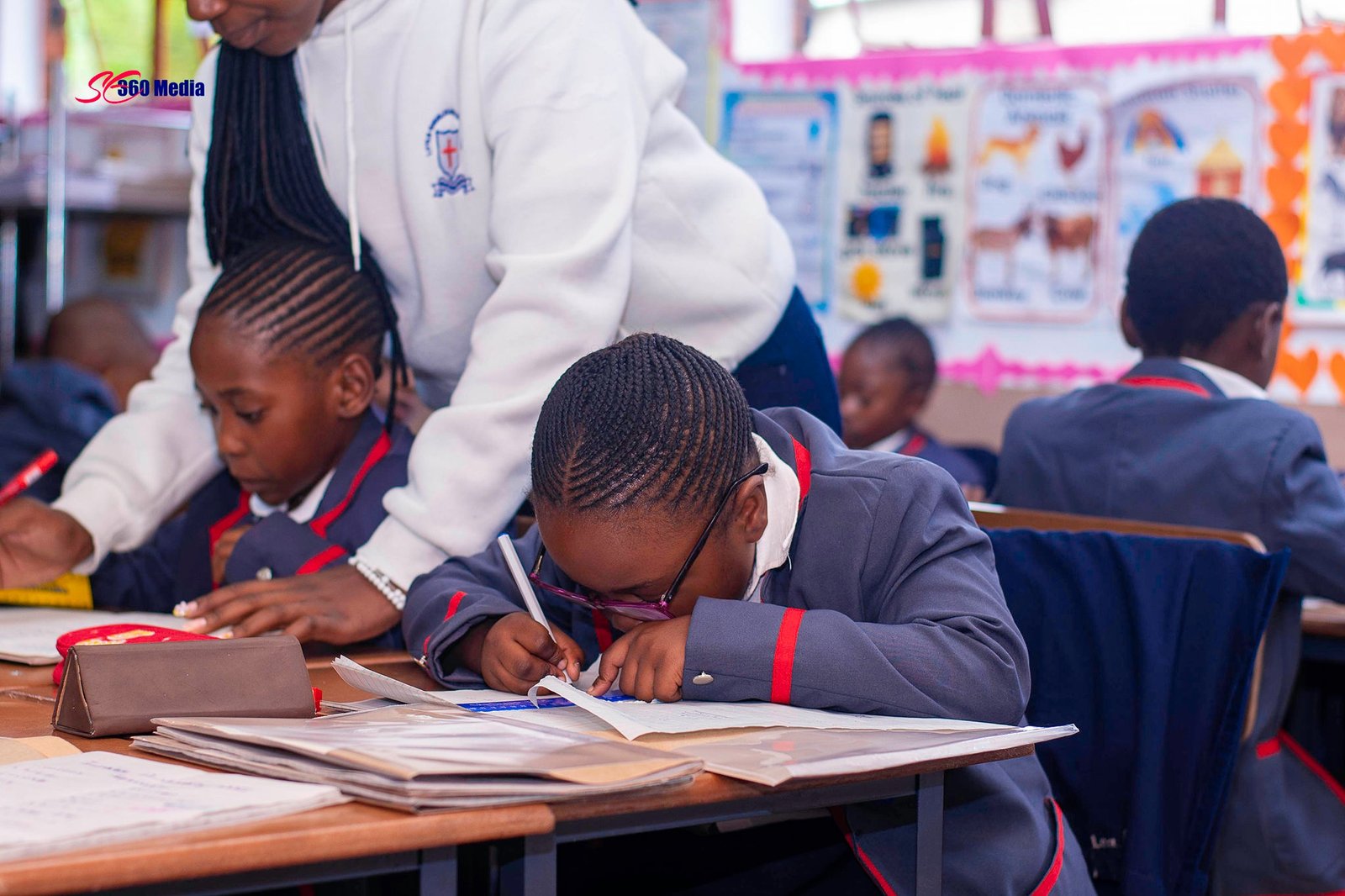 Teacher helping a primary pupil in class